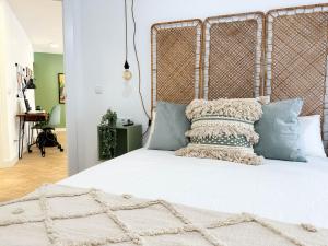 a bedroom with a large white bed with blue pillows at Elegante apartamento a unos pasos de la Rambla. in Alicante