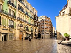 a city street with buildings and people walking around at Elegante apartamento a unos pasos de la Rambla. in Alicante