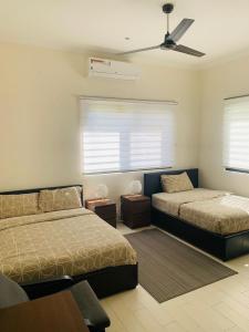 1 dormitorio con 2 camas y ventilador de techo en Relax Serviced Ocean 3bedroom Beach Front House en Bijilo