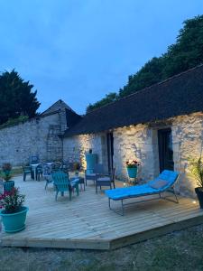 a wooden deck with chairs and a building at Tiny housse la Poitevinière in Neuillé