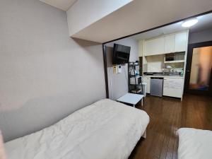 Habitación pequeña con cama y cocina en MORI Apartment2 道頓堀(Dotonbori) 1K, en Osaka