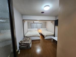 Habitación con 2 camas y sofá. en MORI Apartment2 道頓堀(Dotonbori) 1K, en Osaka