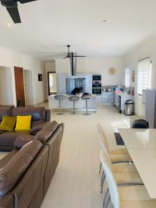 een woonkamer met een bruine bank en een keuken bij Relax Serviced Ocean 3bedroom Beach Front House in Bijilo