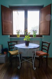una mesa y sillas en una cocina con 2 ventanas en AnimAbruzzo, en Cepagatti