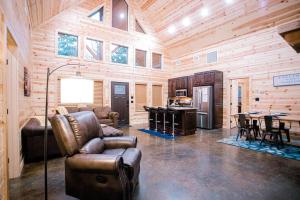 a living room with leather furniture in a wooden cabin at Crystal Moon in Broken Bow
