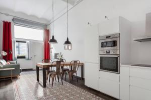 a kitchen with a table and a dining room at Stylish Apartment with Terrace for Couple or Family in Barcelona