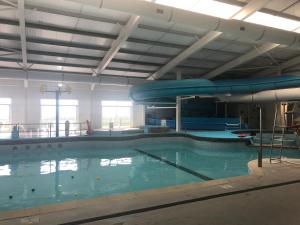 a large swimming pool with a slide in it at Cockleshell Chalet in Kidwelly