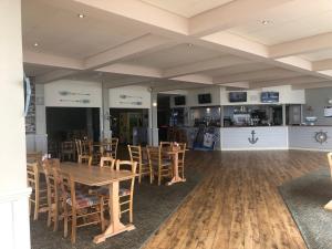 a dining room with wooden tables and chairs at Cockleshell Chalet in Kidwelly +11 photos