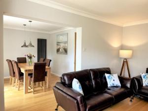 a living room with a leather couch and a table at Linden Lea in Plymouth