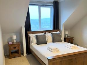 a bedroom with a bed with a large window at Linden Lea in Plymouth