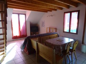 un soggiorno con tavolo, sedie e finestre di Le Massif des Ecrins a Les Clots Altre 4 foto