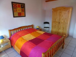 una camera da letto con un letto colorato e una sedia di Le Massif des Ecrins a Les Clots