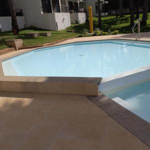 una gran piscina en un patio en Relax Serviced Ocean 3bedroom Beach Front House, en Bijilo