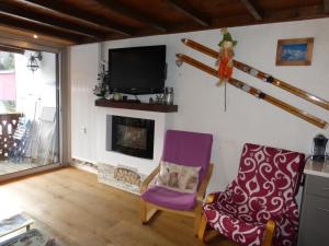 een woonkamer met 2 stoelen en een open haard bij Les Seolanes Pra Loup 520 in Pra-Loup