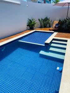 uma piscina com azulejos azuis numa casa em Cabo Frio FamiliarToca de Gente Feliz em Cabo Frio
