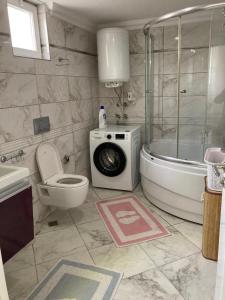 een badkamer met een douche, een toilet en een wasmachine bij Ottoman village in Okurcalar