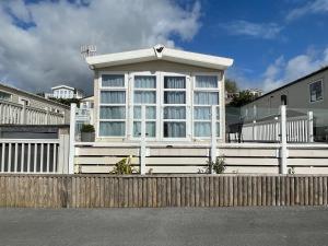 Casa blanca con valla de madera en Ladram Bay Holiday Park D54 en Otterton