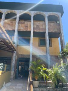 a building with palm trees in front of it at Pousada Sol Da Pipa in Pipa