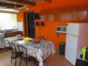 cocina con mesa con sillas y nevera blanca en Casa Vacanze Sole & Luna, en Milazzo