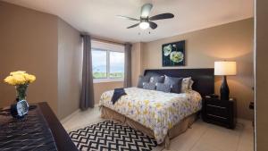 a bedroom with a bed with a ceiling fan and a window at Modern- Renovated- Breathtaking 6th Floor- 3 Bedrooms Villa Magna in Nuevo Vallarta  +34 photos