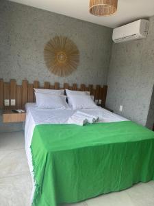 sypialnia z dużym łóżkiem i zielonym kocem w obiekcie Nauru chalés milagres w mieście São Miguel dos Milagres