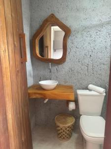 a bathroom with a sink and a toilet and a mirror at Nauru chalés milagres in São Miguel dos Milagres