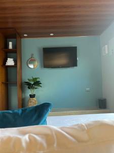 a bedroom with a bed and a tv on a wall at Miss Anto´s Place-MAP in San Andrés