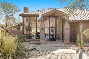 a home with glass doors and a stone walkway at Canyon Crest Condo in Tucson