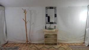 a bathroom with a sink and a mirror on a wall at Merzouga Activities Camp in Merzouga