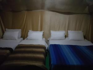 two beds sitting next to each other in a room at Merzouga Activities Camp in Merzouga