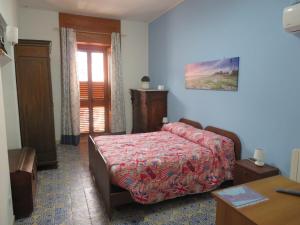 a bedroom with a bed and a table and a window at Casa Vacanze Sole & Luna in Milazzo
