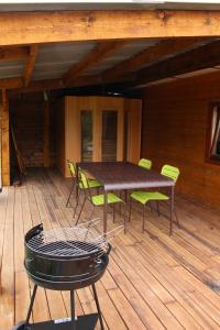 un patio con mesa y sillas en una terraza en Chalet du Lièvre, en Hannappes