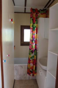 a bathroom with a shower curtain and a sink at Chalet du Lièvre in Hannappes