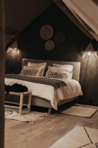 a bedroom with a bed with lights on the wall at Pause Cachée in Walhain-Saint-Paul