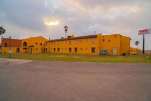 une rue vide devant un bâtiment jaune dans l'établissement OYO Hotel Kingsville - Hwy 77, à Kingsville