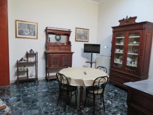 a dining room with a table and a grandfather clock at Casa Vacanze Sole & Luna in Milazzo