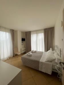 a bedroom with a large bed with white sheets and pillows at Parco Fibonacci in Montefano