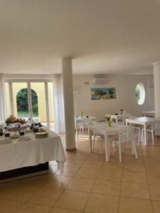 a dining room with white tables and white tables at Parco Fibonacci in Montefano