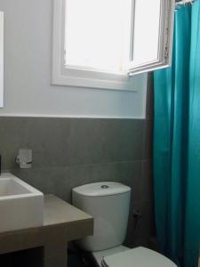 a bathroom with a toilet and a sink and a window at 'Paradise' by Cnn - Delfini Bay - 3Bed House in Ano Syros +12 photos