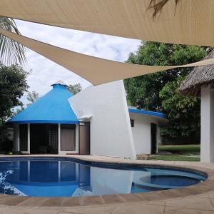 a house with a blue roof and a swimming pool at Casa San José in El Conacaste