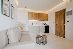 un soggiorno con divano bianco e tavolo di Aelia Prime Experience 1 a Città di Kos