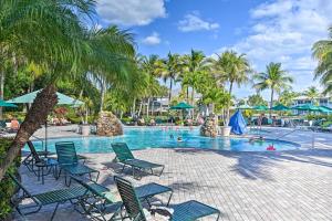 una piscina con sillas y palmeras en un complejo en Luxury Golf Villa in Beautiful Lely Resort with Pool en Naples