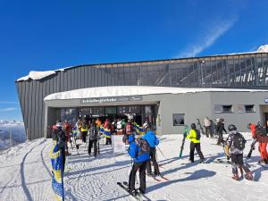 a group of people on skis in the snow outside a building at Apart Ehart in Schnann