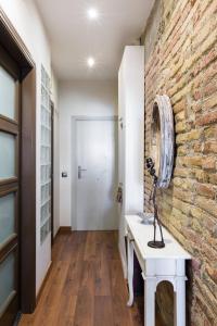 バルセロナにあるSant Antoni Lovely Apartmentのレンガの壁と白いテーブルのある廊下