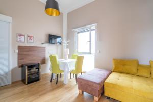 a living room with a yellow couch and a table at Pension Pannonia in Parndorf