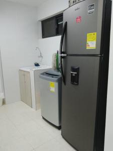 uma cozinha com um frigorífico e duas latas de lixo em HERMOSO Apartamento con piscina y cerca a PLAYA. em Santa Marta
