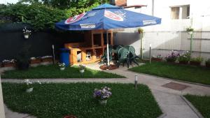 a blue umbrella and two chairs under a table at Vila Raduinea in Eforie Nord