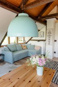 uma sala de estar com um sofá azul e flores numa mesa em Loft auf Fehmarn 800m zum Strand em Fehmarn