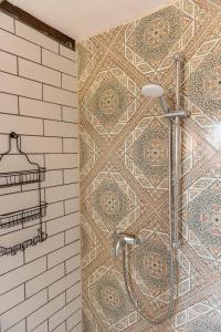 y baño con ducha y pared de mosaico. en Loft auf Fehmarn 800m zum Strand, en Fehmarn