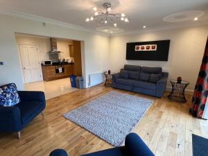 - un salon avec deux canapés bleus et un tapis dans l'établissement 24 Castle Hume Court Holiday House, à Enniskillen